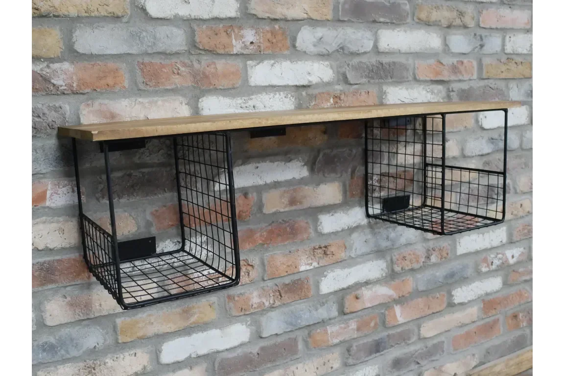 Wooden wall shelf with two black wire storage baskets on exposed brick wall