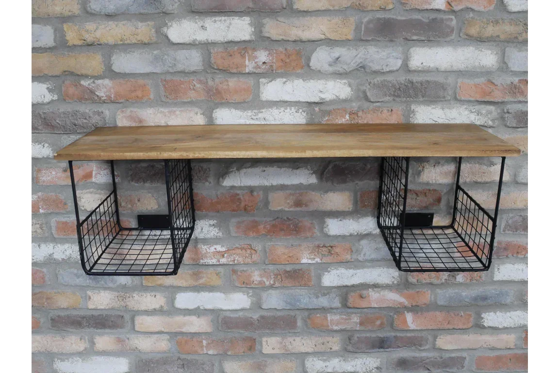Wall shelf with wooden top and black wire storage baskets on exposed brick wall