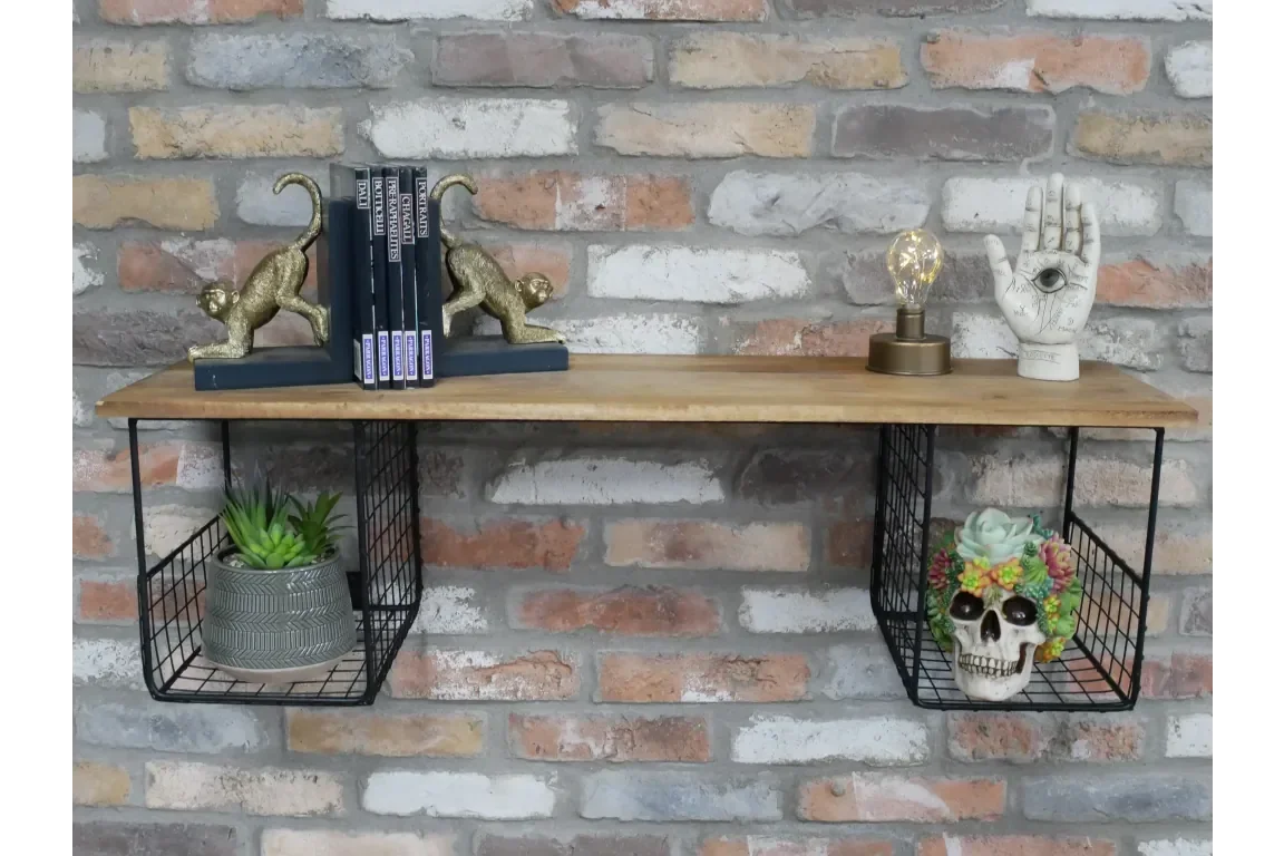 wooden wall shelf with black wire baskets, gold monkey bookends, books, lamp, potted succulents