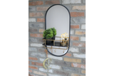Oval wall-mounted mirror with black frame, gold metal shelf and hooks, shown with potted plant and decorative bulbs.