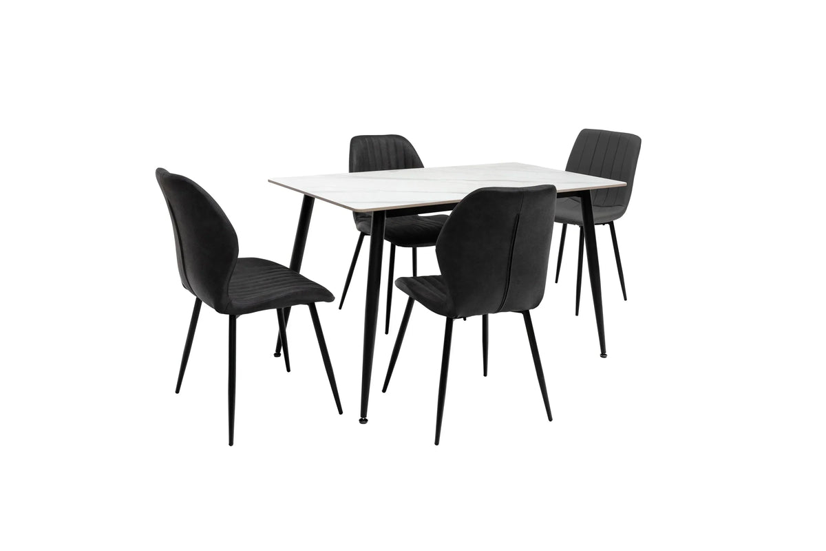 Modern dining table set with white top and four black upholstered chairs on black metal legs