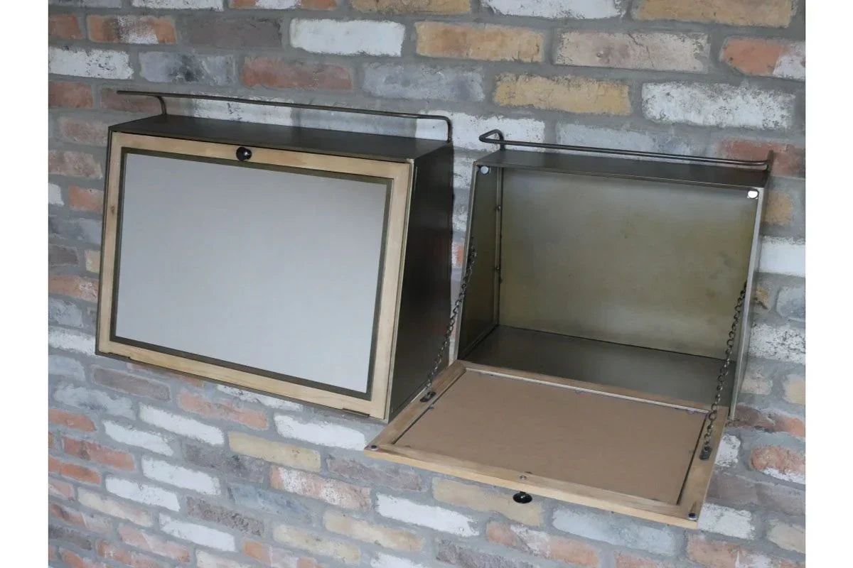 Wall mounted metal storage cabinet with drop-down door against exposed brick wall