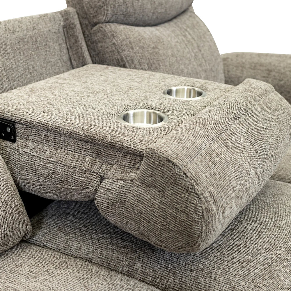Close-up of a gray upholstered recliner chair with a center armrest featuring two cup holders and a power control switch, set against a plain white background.