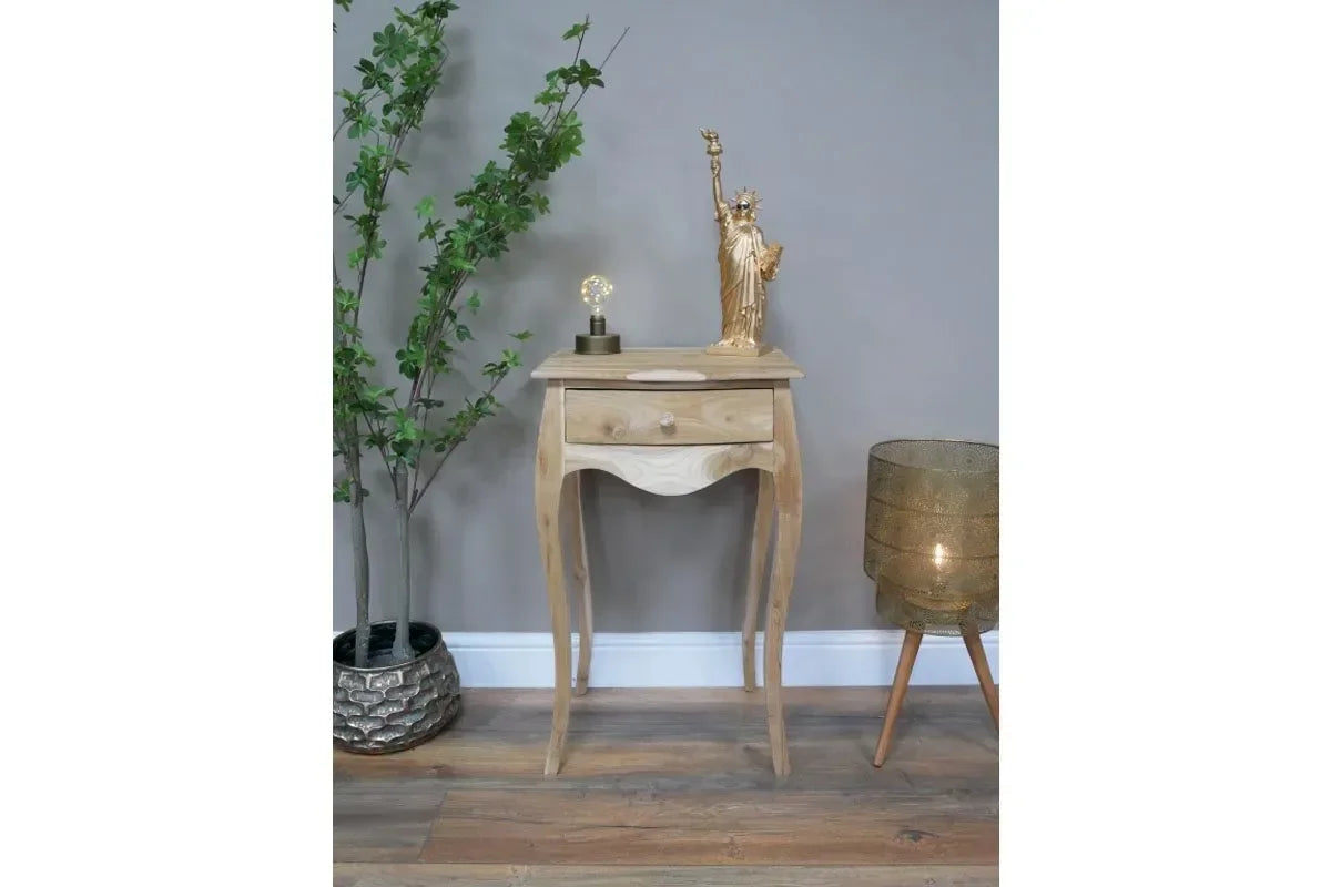 Natural wood bedside table with curved legs and single drawer in modern living room setting