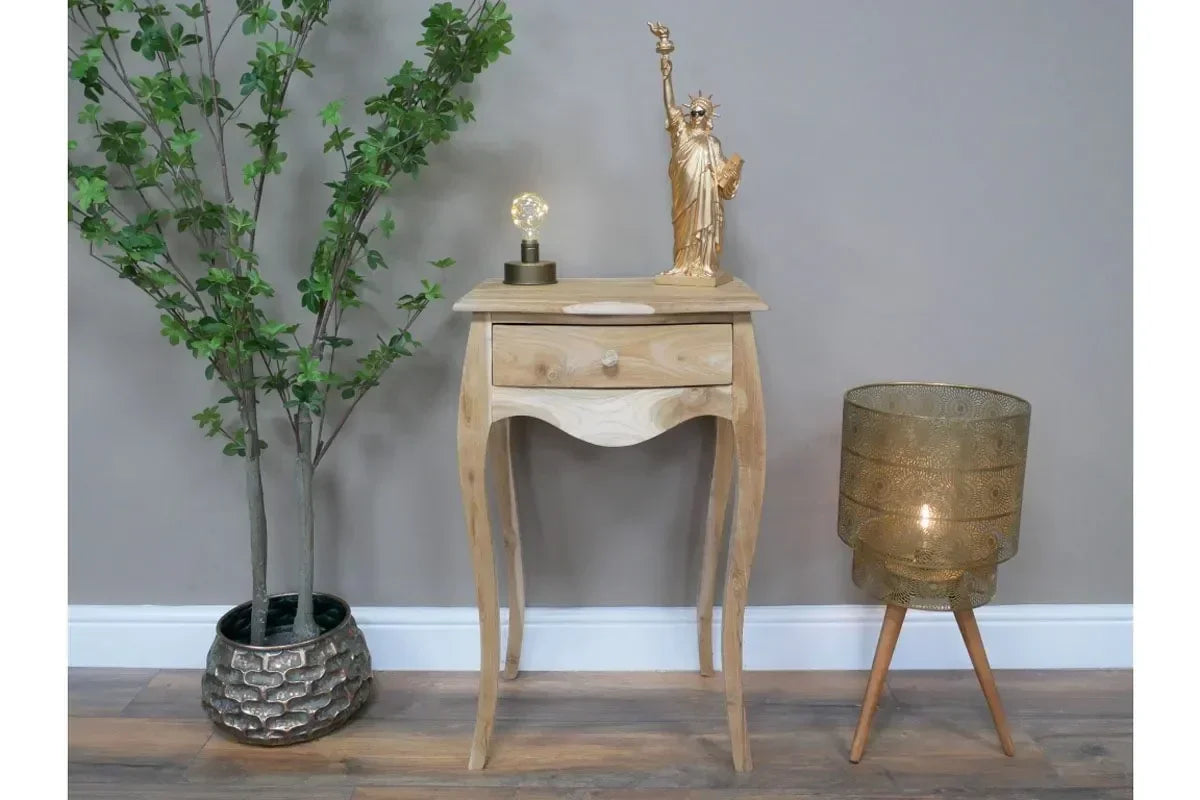 Natural wood bedside table with single drawer, styled with lamp and decor, in modern room