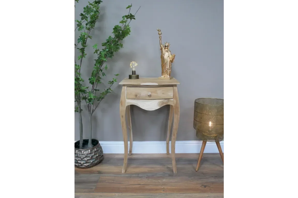 Solid wood bedside table with single drawer, curved legs, natural finish, staged with decor