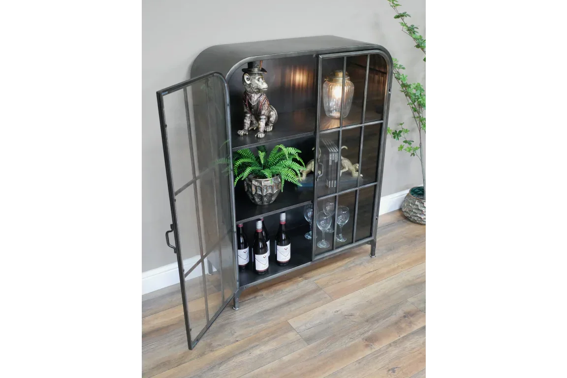 Black metal display cabinet with glass doors, shelves holding decor, wine bottles and glassware