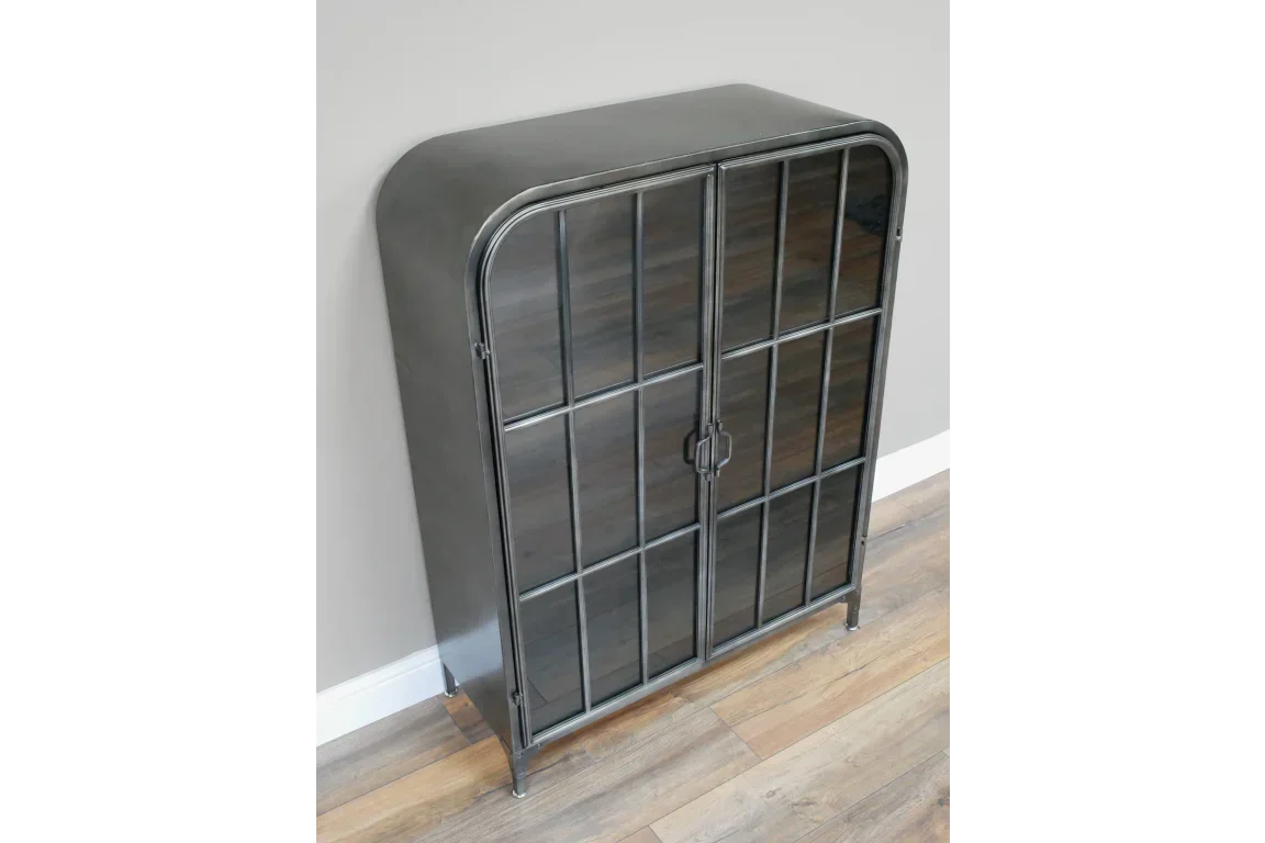 Industrial metal display cabinet with glass doors and black grid frame on wood flooring