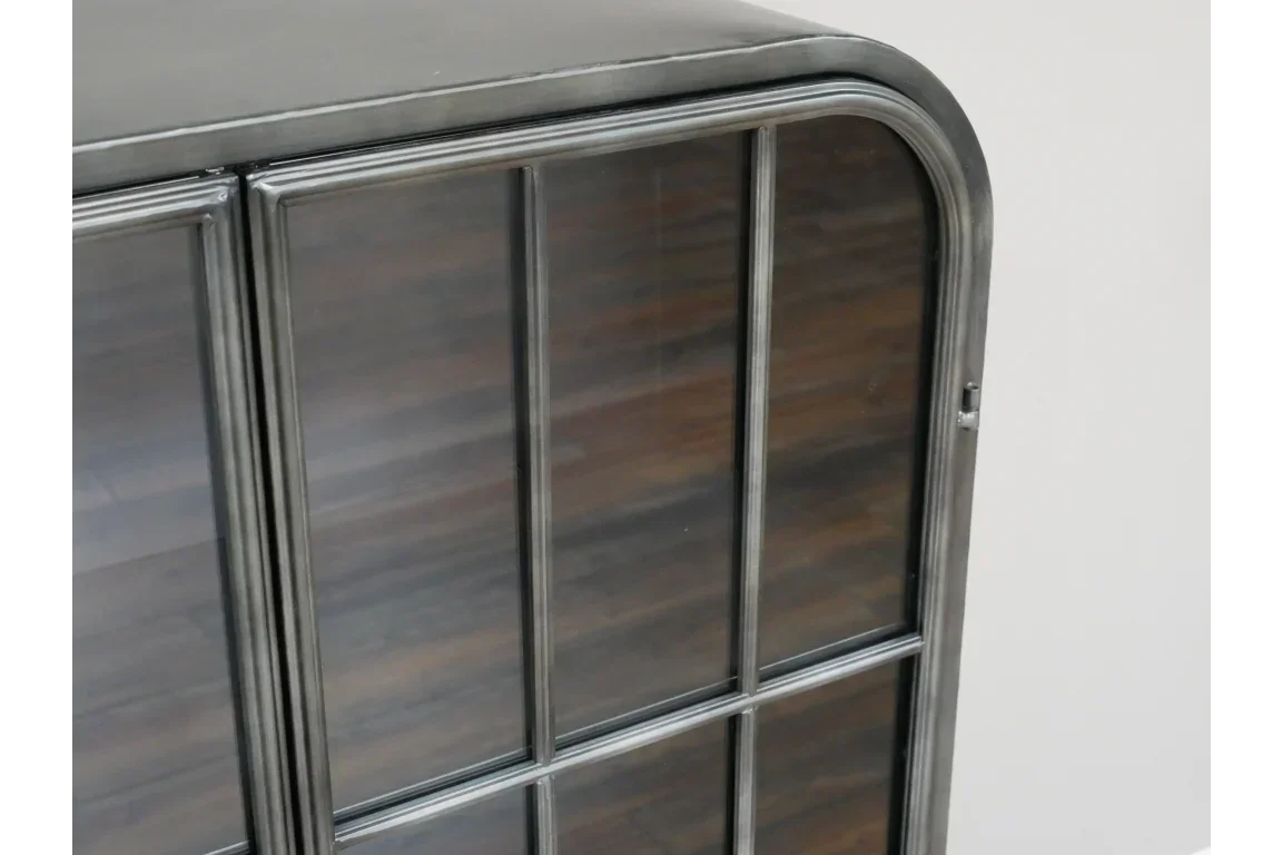 Closeup of metal display cabinet door with glass panels and dark wood interior shelves