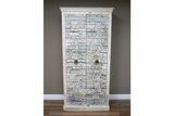 Large wooden cabinet with intricate carved patterns, whitewashed finish, two metal ring handles, standing on wooden floor.