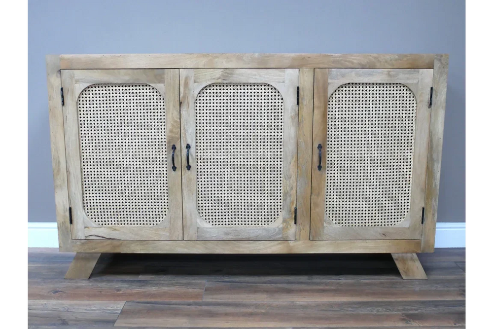 Natural wood sideboard with three cane panel doors and black handles on wood floor