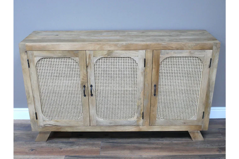 Natural wood sideboard with rattan doors and black handles on laminate floor