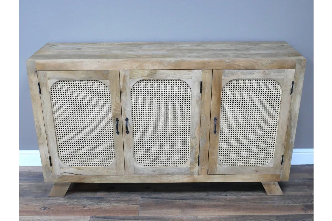 Natural wood sideboard with rattan doors and black handles on laminate floor