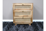 This small chest of drawers features a natural wood finish with three woven rattan front panels and round brass knobs, providing a stylish storage solution