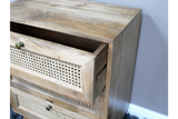 This small chest of drawers features a natural wood finish, three woven rattan front drawers, and round metal knobs, adding a rustic touch to any space