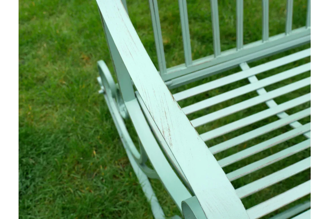 Close-up of pale green wooden garden bench with slatted seat on grass