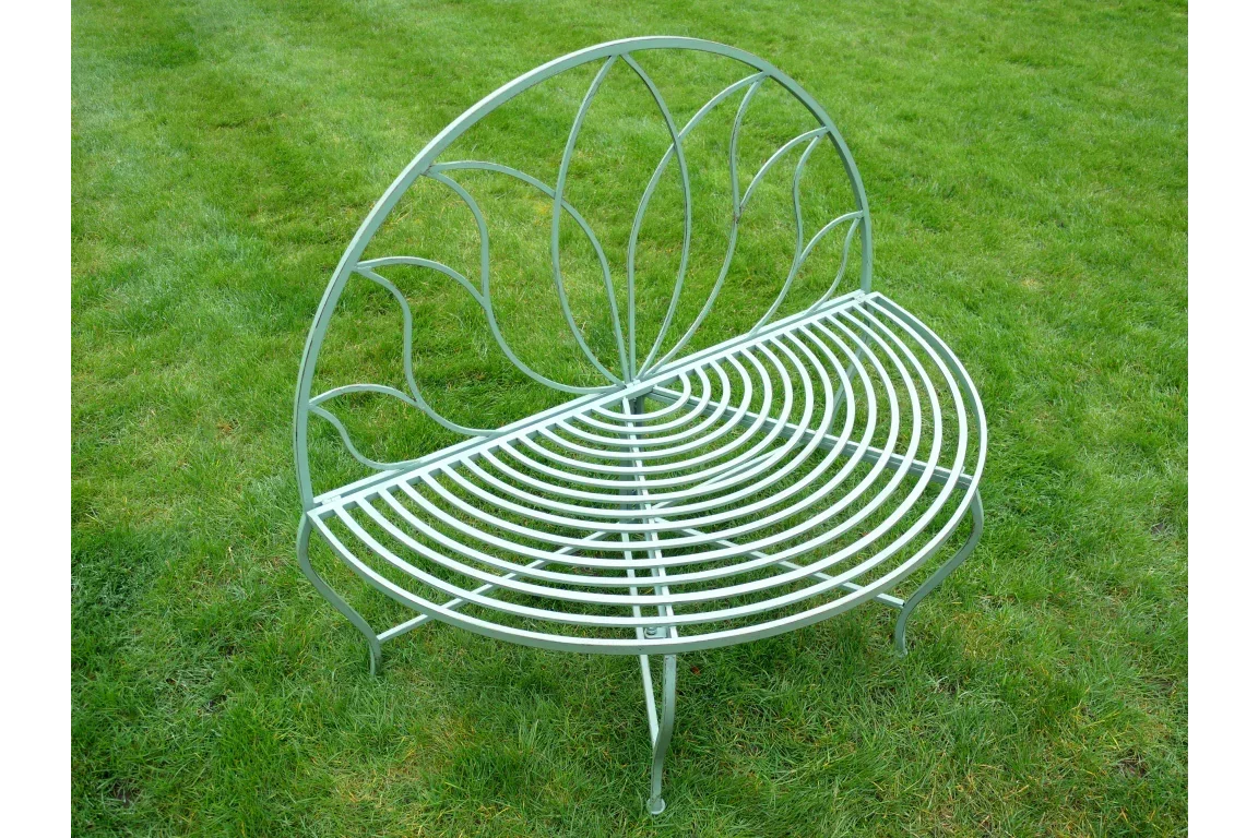 curved metal garden bench with decorative backrest on lawn