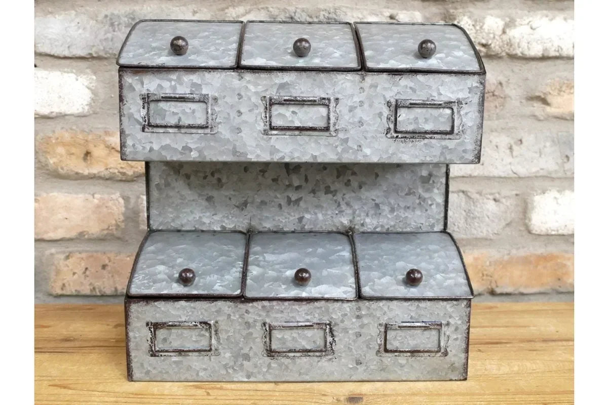 Galvanised metal storage drawers with label holders and round knobs on wooden surface