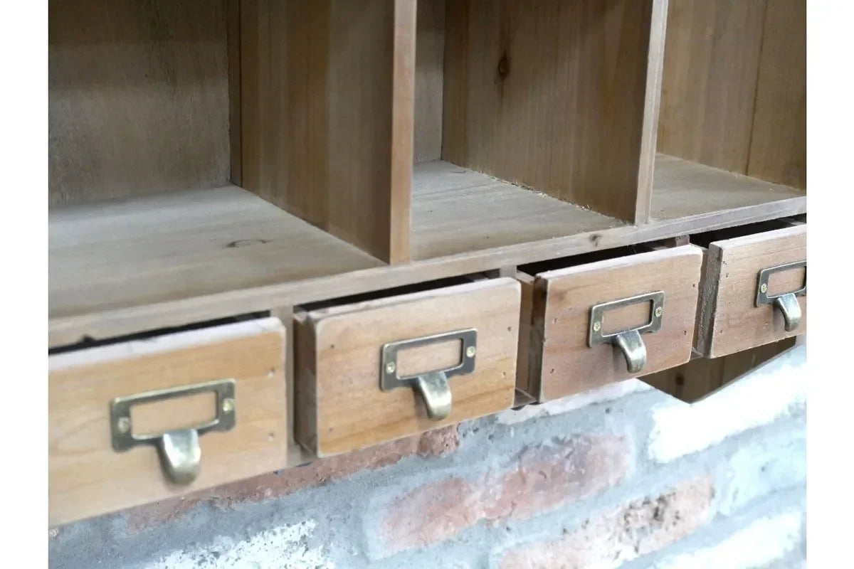 Wooden wall shelf with storage drawers and brass label handles above exposed brick