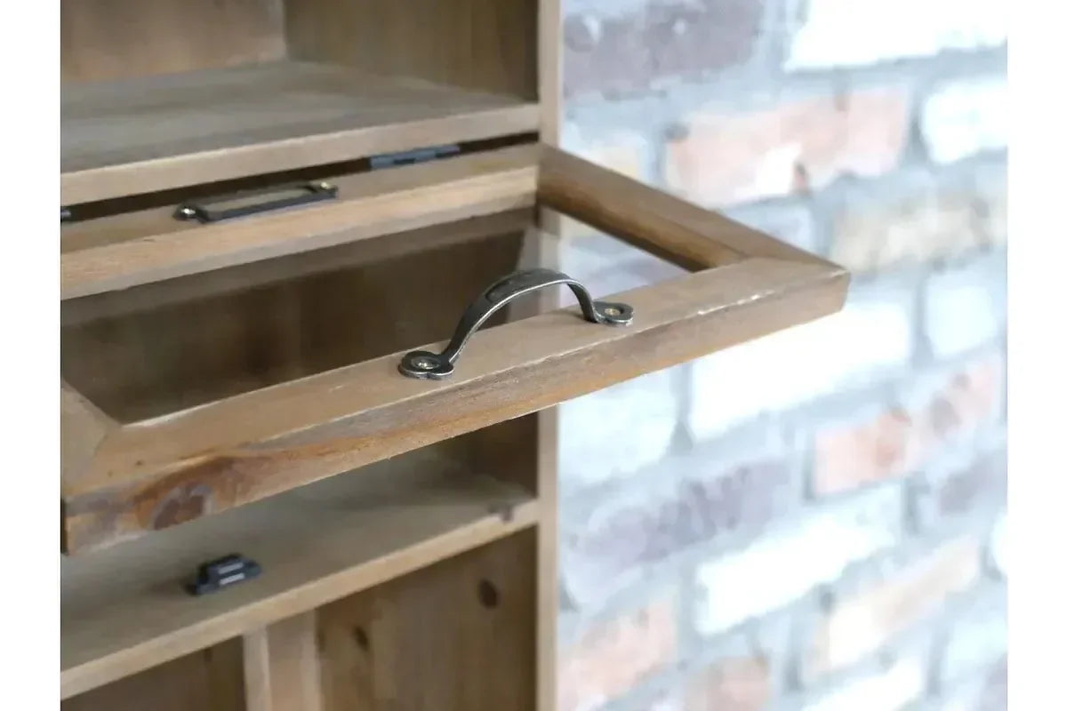 Closeup of wooden cabinet drop-down door with metal handle and open storage compartments