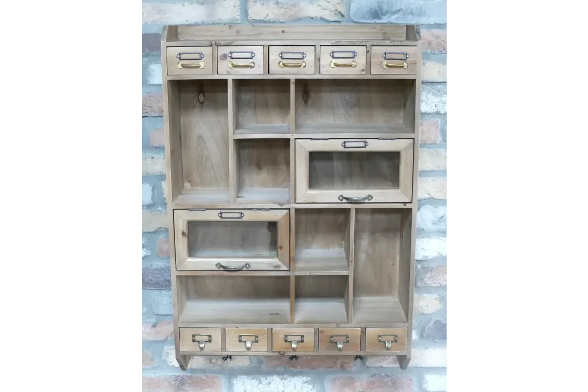 Wooden storage cabinet with multiple drawers and compartments against brick wall