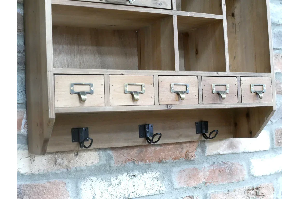 Wooden wall mounted storage unit with drawers and metal hooks fixed to brick wall