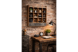 Wall unit with 12 open wooden cubbies and a dark drawer, mounted on a brick wall above a wooden desk.