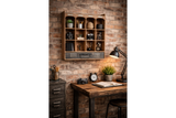 Wall unit with 12 open wooden cubbies and a dark drawer, mounted on a brick wall above a wooden desk.