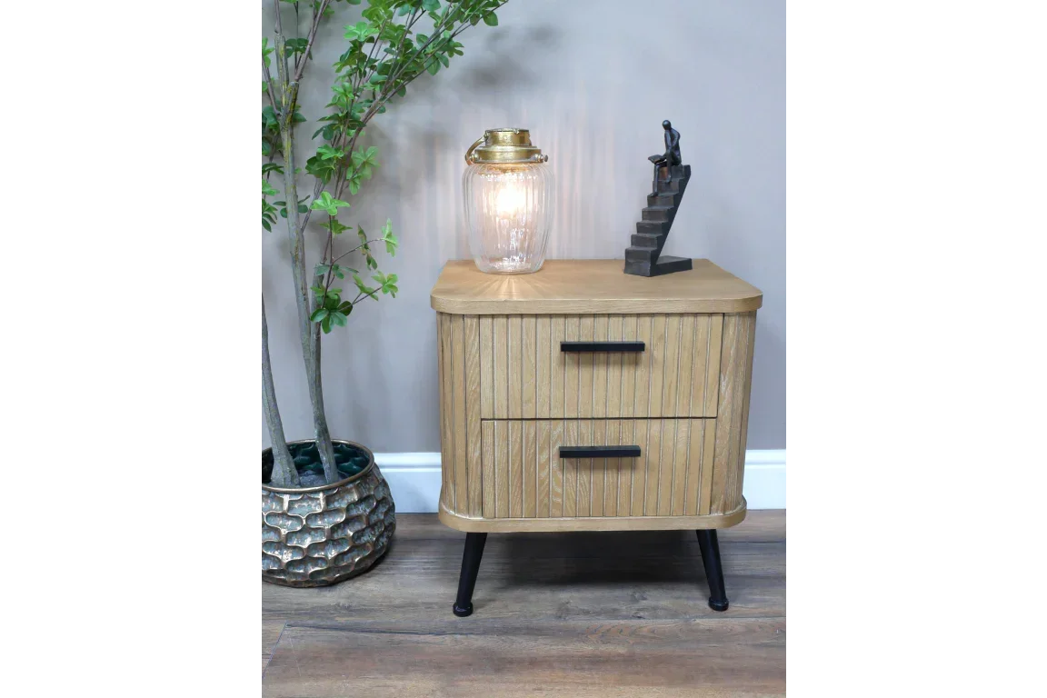Oak bedside table with two drawers, black handles and legs, styled with lamp and sculpture