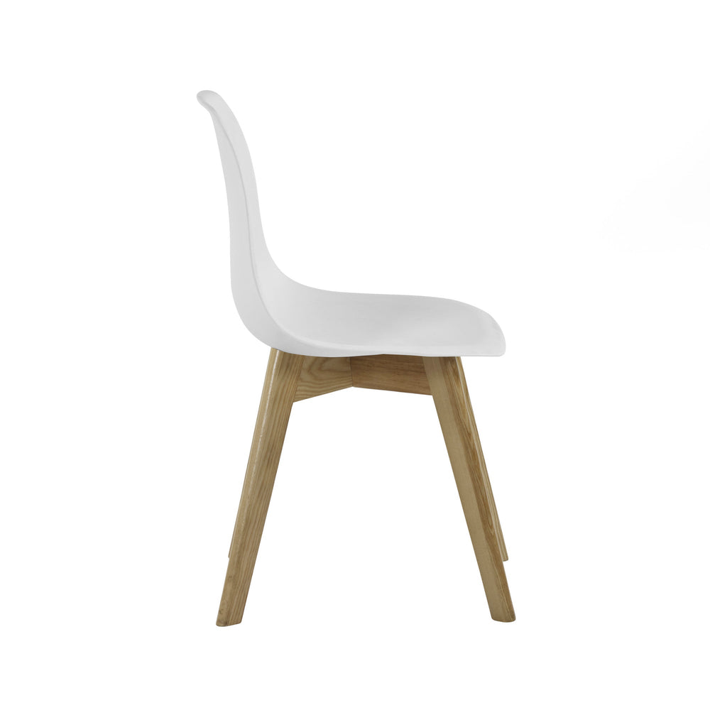Back side view of white molded plastic dining chair with angled wooden legs near oak table