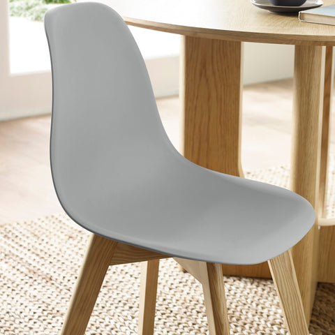 Close-up side view of grey seat with wooden legs under natural wood dining table