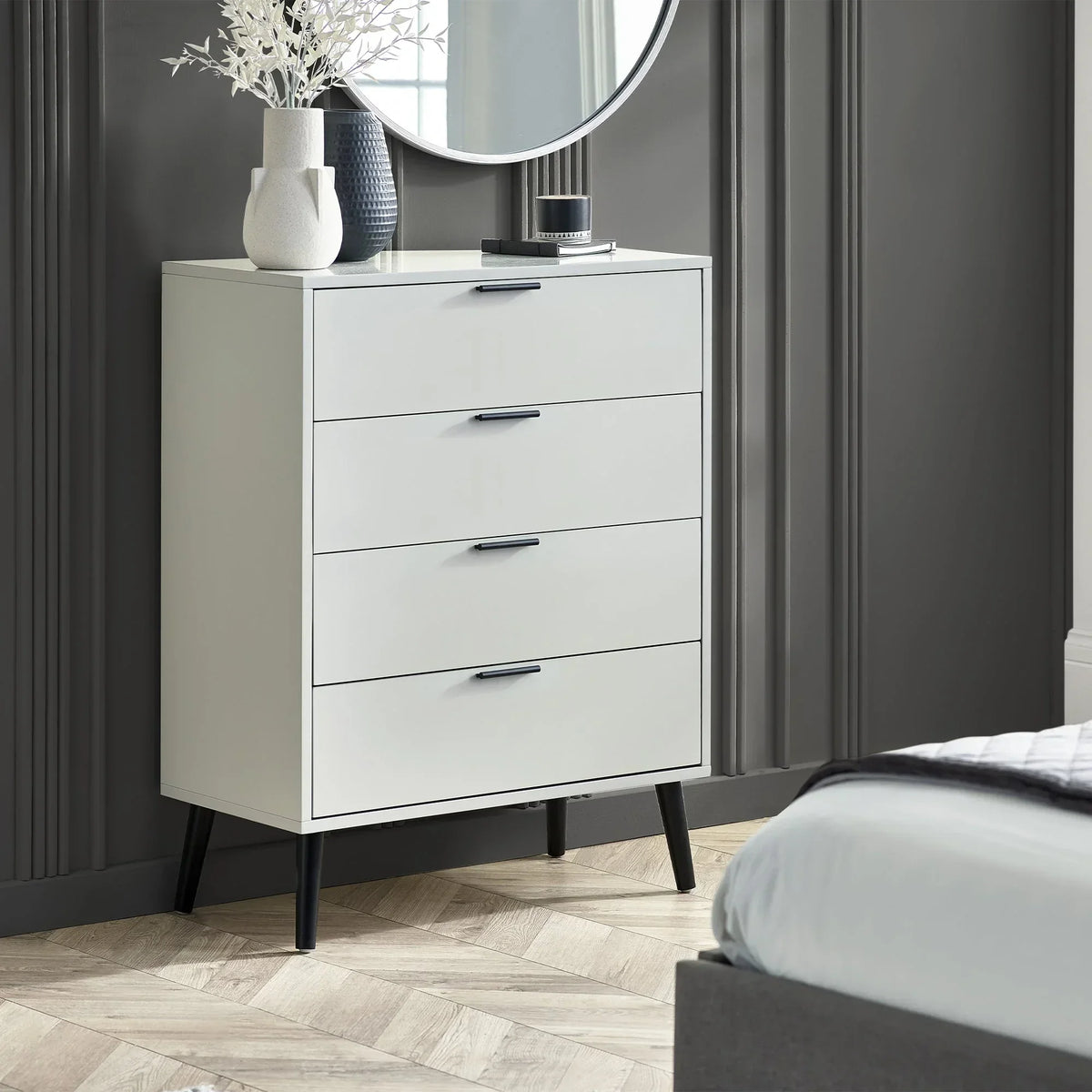 Silk grey four drawer chest with black handles in a modern bedroom setting