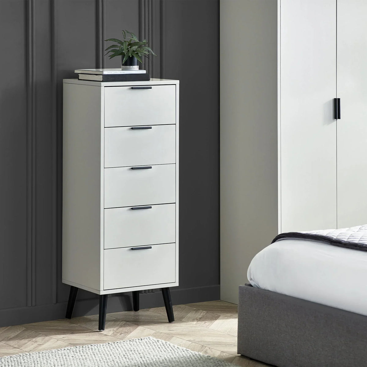 Silk grey five drawer chest with black handles and legs in modern bedroom