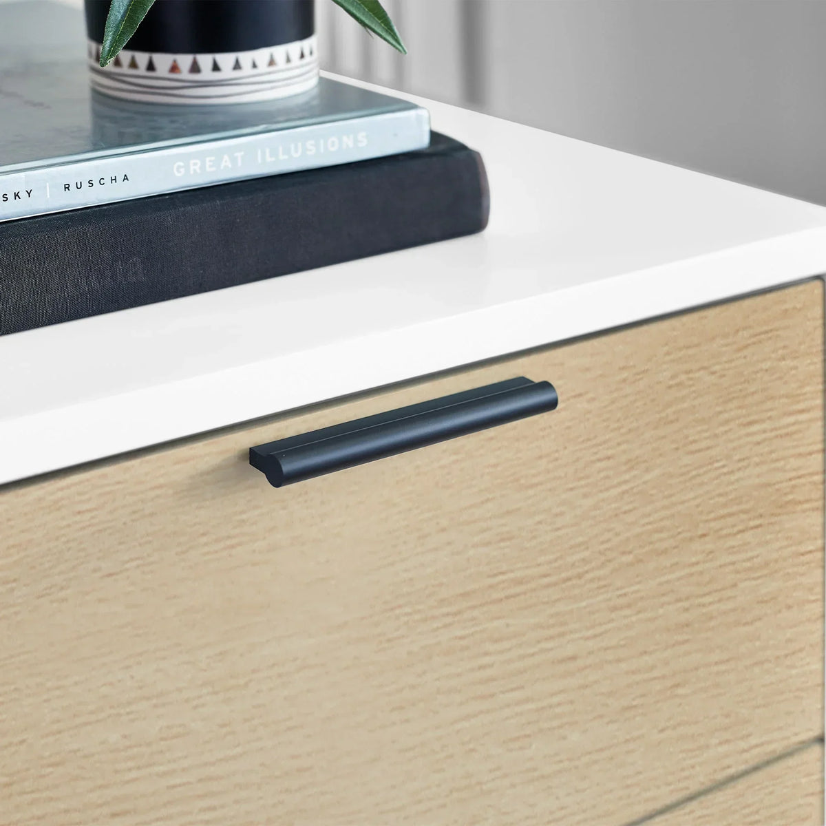 White and oak bedside table drawer with black handle, close-up detail view