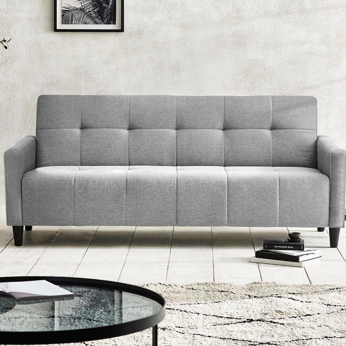 Light grey fabric sofa with square tufted upholstery in modern living room setting