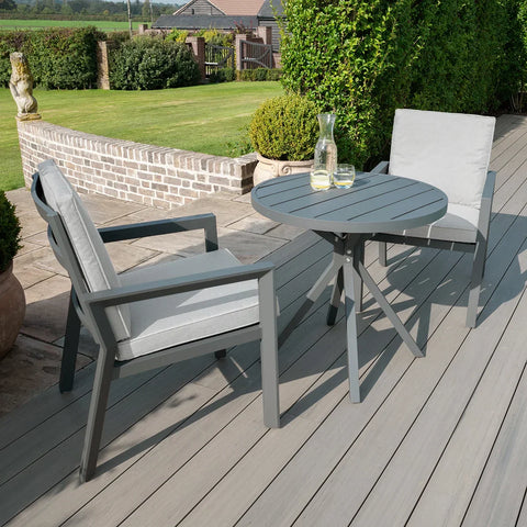 Grey outdoor aluminum bistro set with two cushioned chairs and round table on patio deck