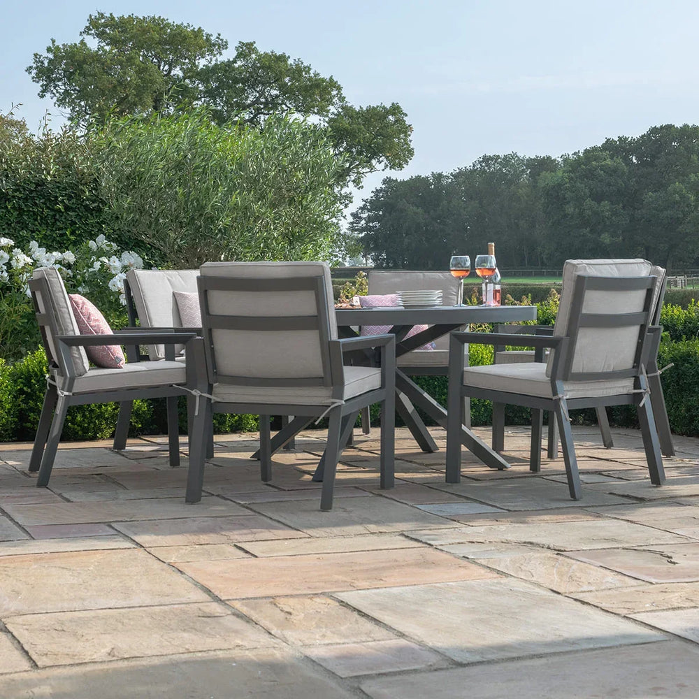 Grey aluminium garden dining set with cushioned chairs on stone patio, outdoor setting