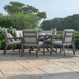 Grey aluminium garden dining set with cushioned chairs on stone patio, outdoor setting