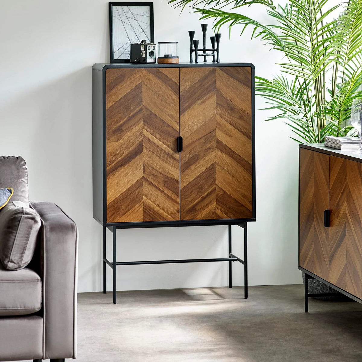 Chevron wood cabinet with black metal legs in modern living room setting