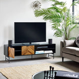 Modern TV unit with wood and black finish, open shelves, styled in living room with indoor plant