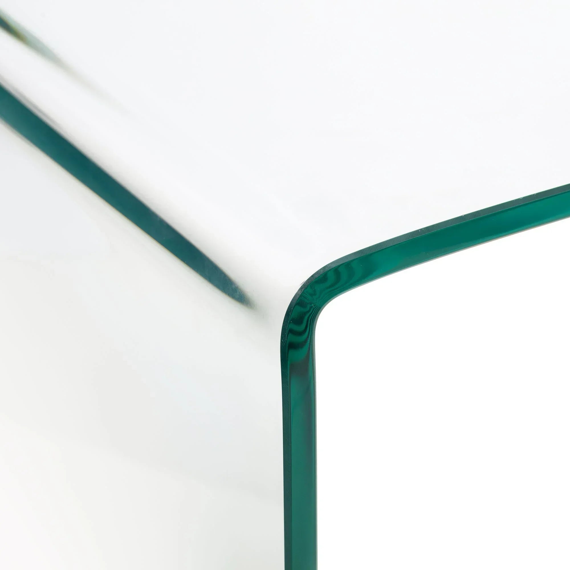Curved edge detail of clear glass desk with green-tinted border