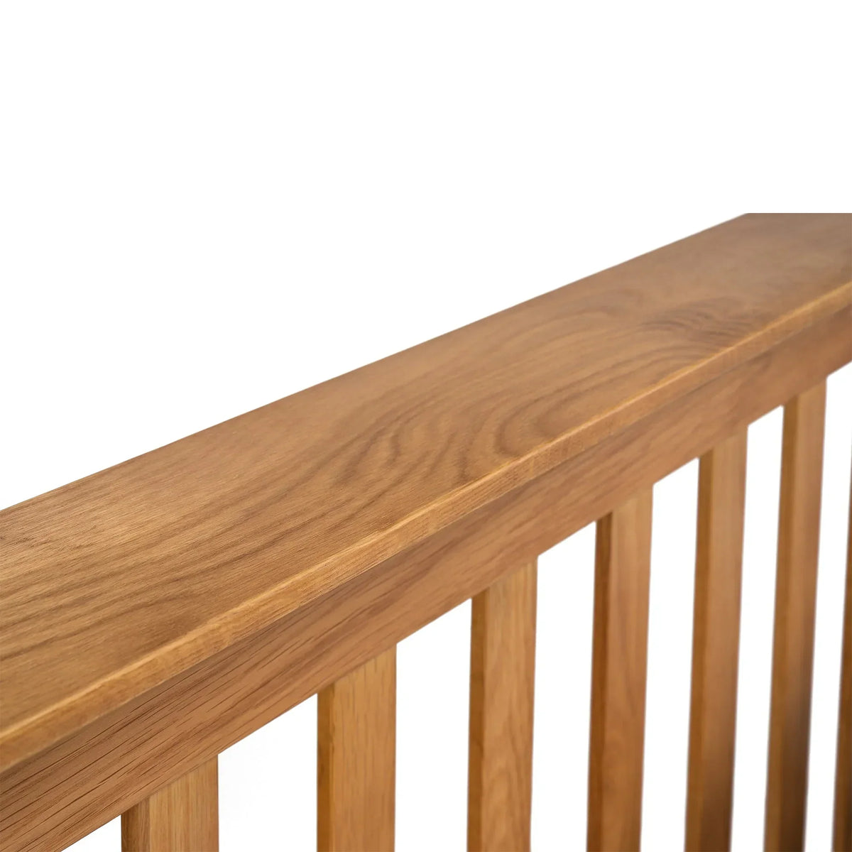 Close up of oak bed frame headboard with vertical slats and natural wood grain detail