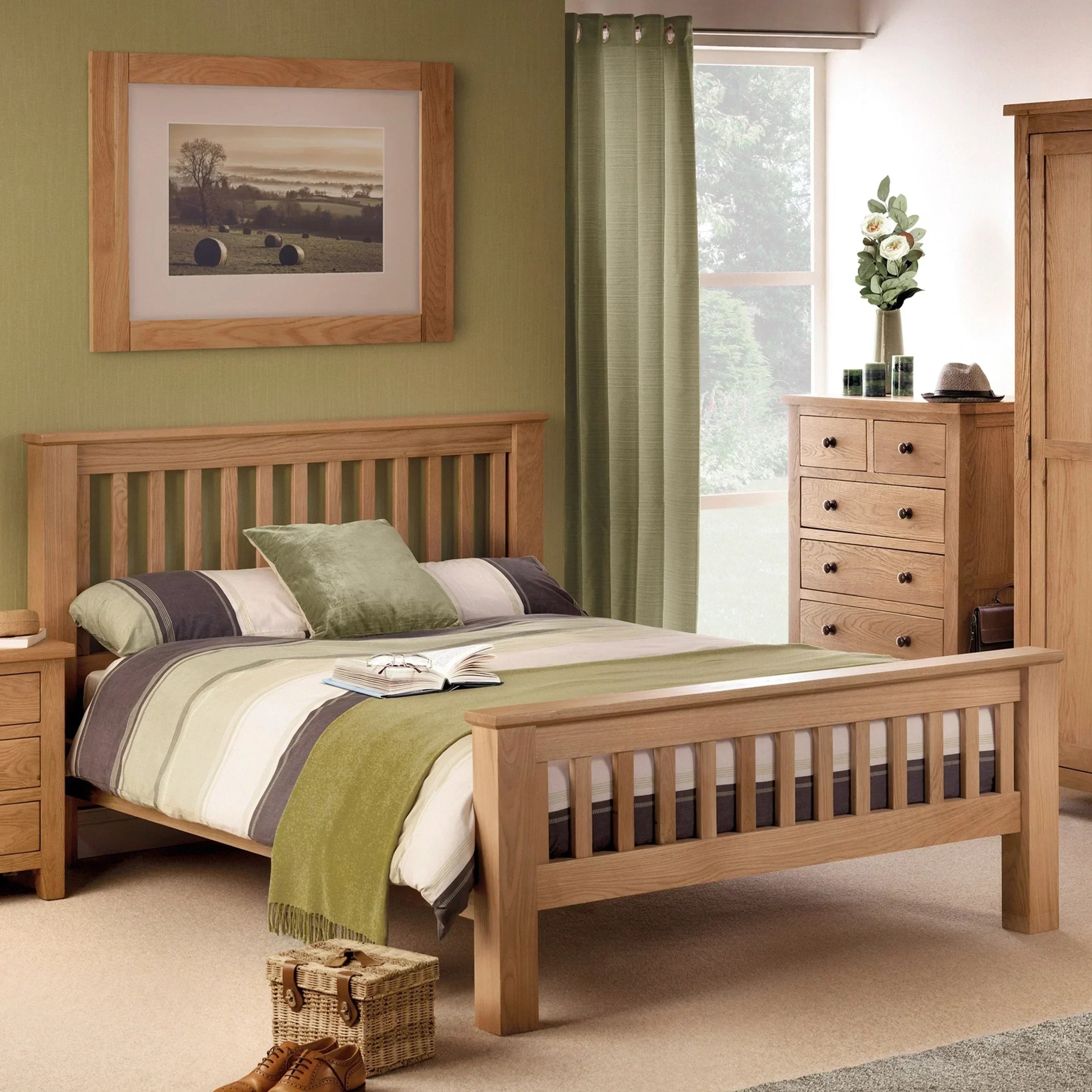 Oak bed frame with striped bedding in modern bedroom with matching wooden furniture