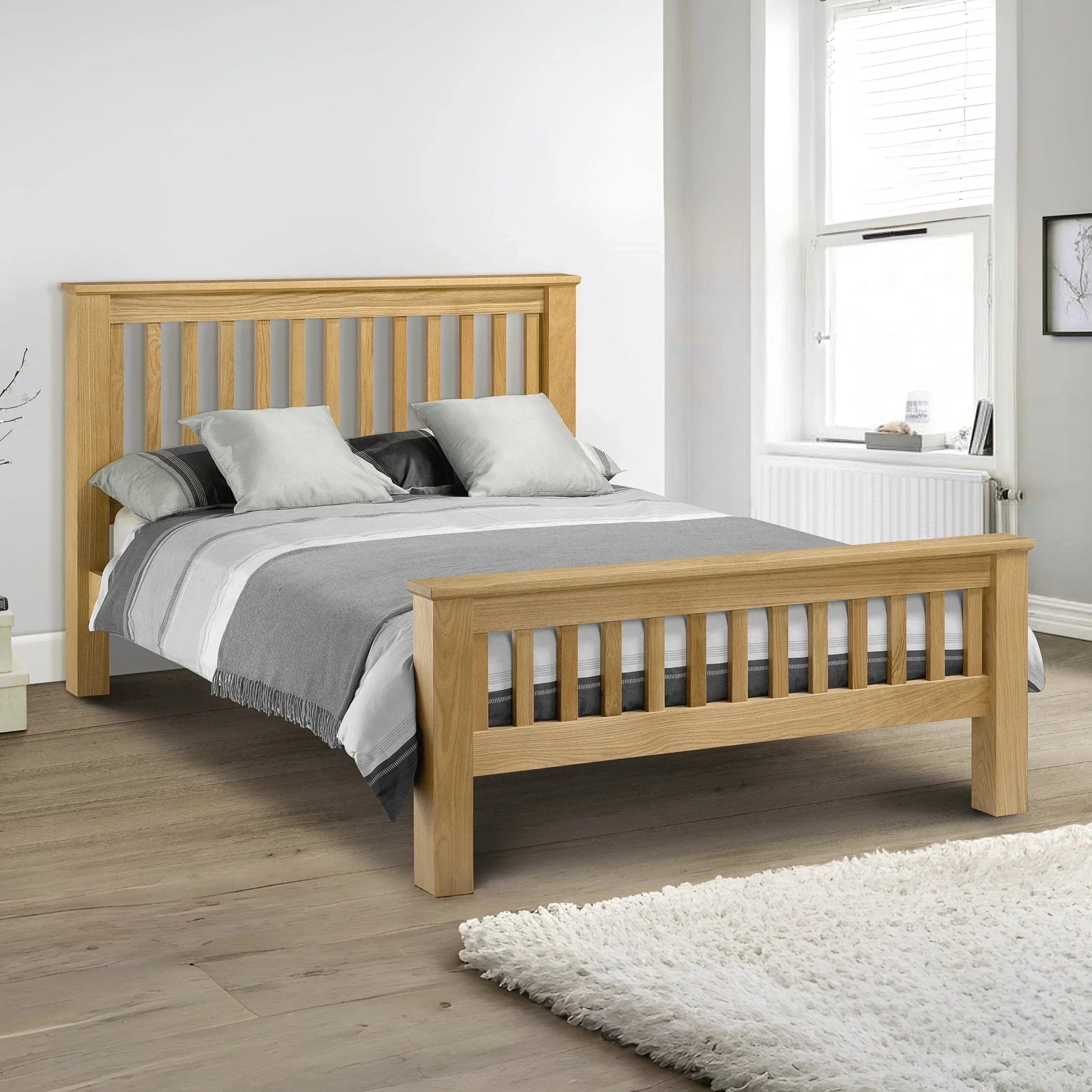 Oak wooden bed frame with slatted headboard and footboard in modern bedroom