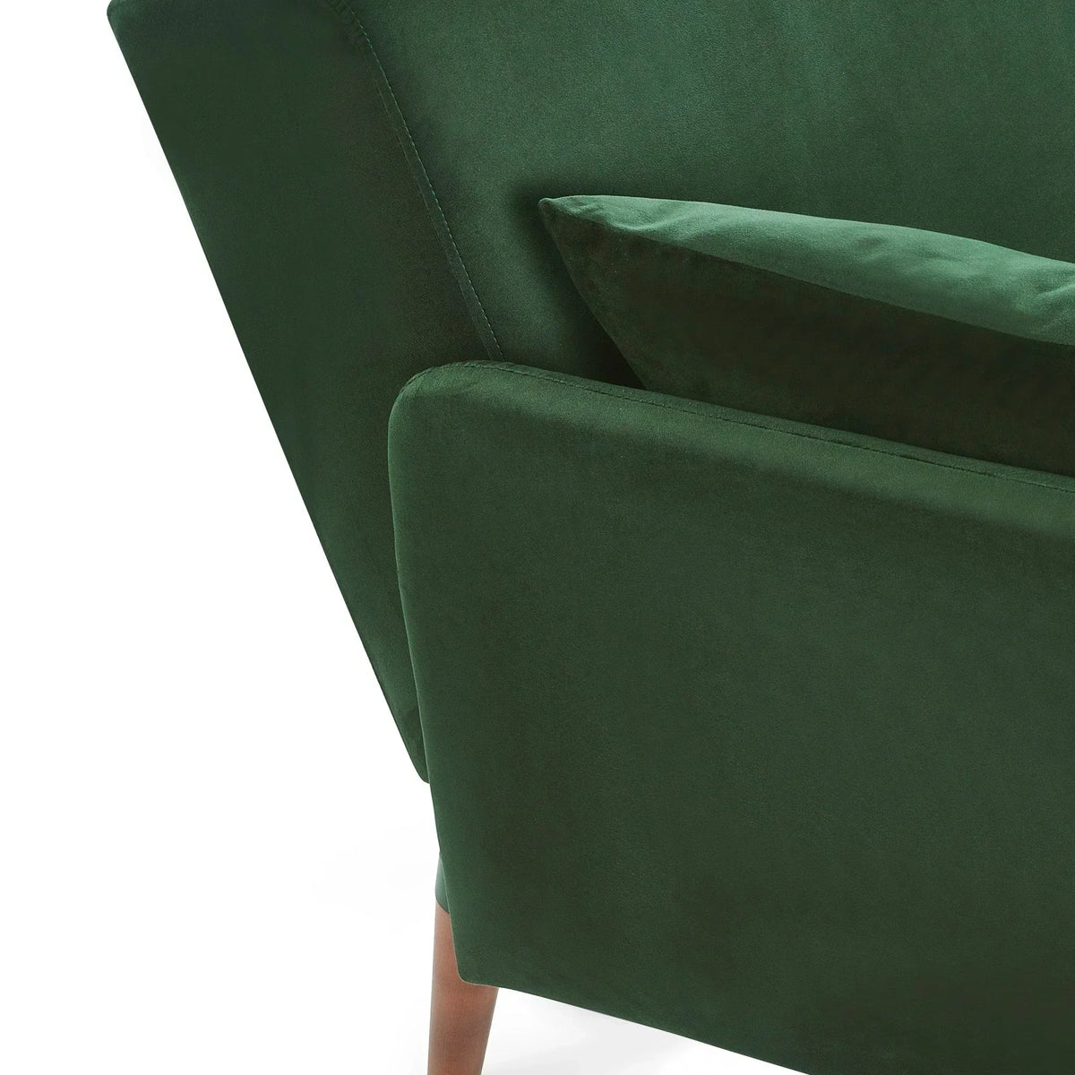 Green sofa bed close-up showing armrest, cushion and wooden leg detail