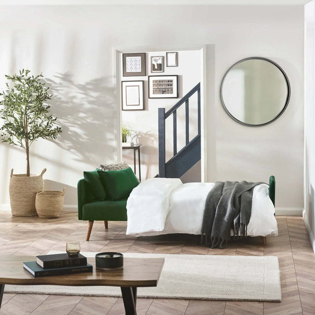 Green velvet sofa bed extended with white bedding in modern living room setting