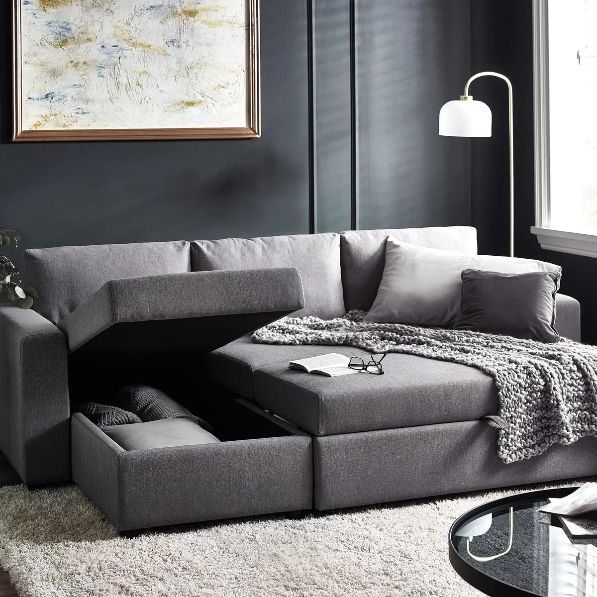 Grey fabric sofabed with open storage compartment in modern living room setting