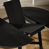 Close-up of black wooden extending dining table partially open showing extension mechanism