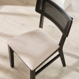 Top view of black dining chair with beige natural fabric seat and rattan backrest on light wood floor