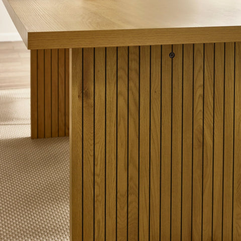 Oak dining table with slatted wooden base and rectangular top on textured beige rug